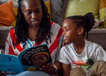 Boy reading with his parent